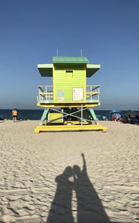 People on beach against clear sky