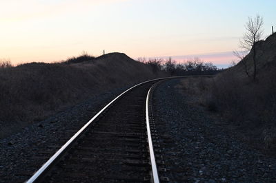 View of railroad tracks against sky during sunset