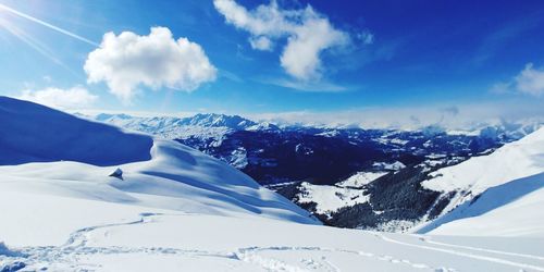 Scenic view of snowcapped mountains against blue sky