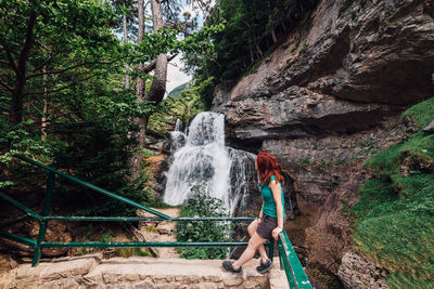 Man splashing water in rock against trees