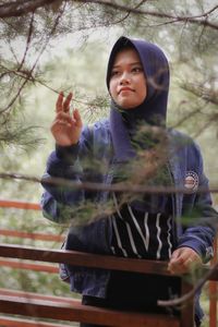 Portrait of girl standing against trees