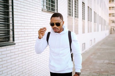 Portrait of young man wearing sunglasses standing outdoors