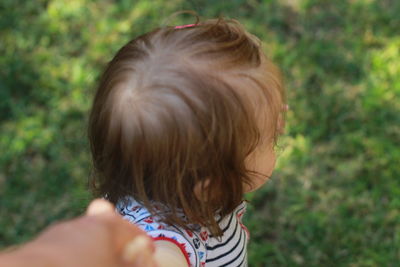 Close-up of baby looking away walking on mamas hand 