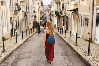 Woman walking against house