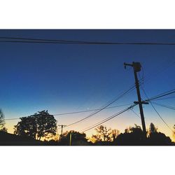 Low angle view of power lines against blue sky