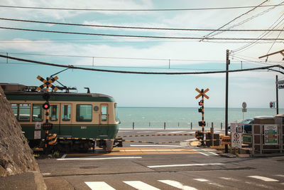 Railroad tracks by sea against sky