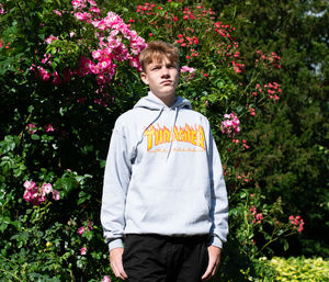 Portrait of boy standing by flower plants