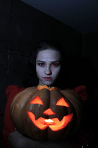 Portrait of woman with pumpkin at home