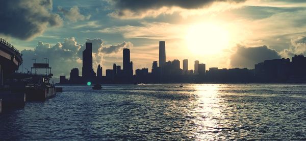 Panoramic view of sea and buildings against sky during sunset