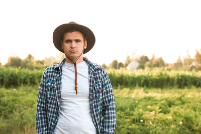 A portrait of a serious farmer standing in a green field. blurred. bad crop and harvest concept.