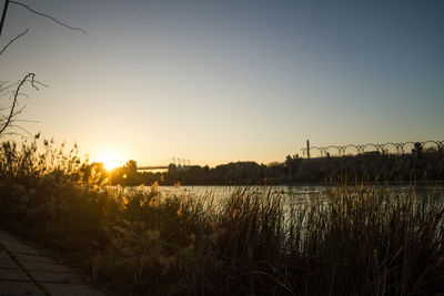 Scenic view of lake against clear sky during sunset