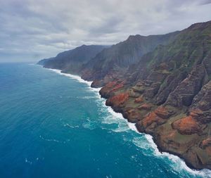 Scenic view of sea and mountains against sky