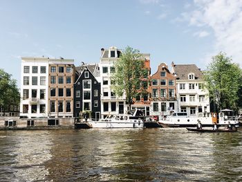 Boats in river with buildings in background