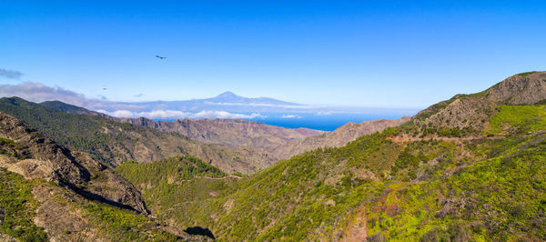 Scenic view of mountains against blue sky