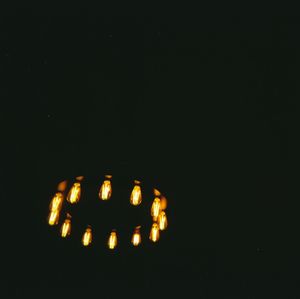 Close-up of illuminated candles against black background