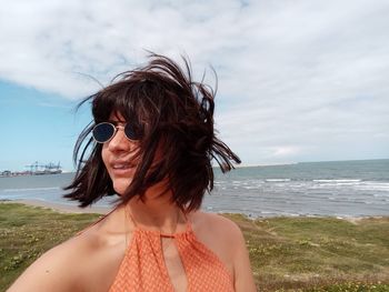 Portrait of woman on beach against sky