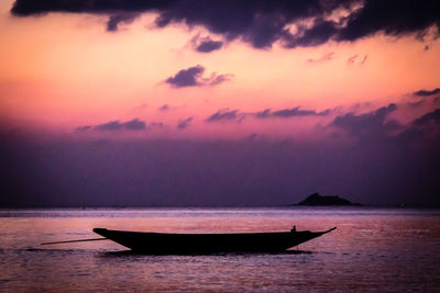 Silhouette boat sailing on sea at sunset