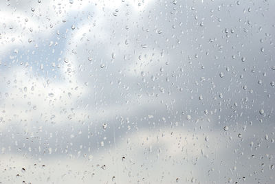 Close-up of rain drops against sky