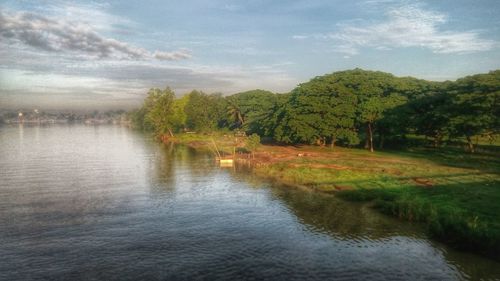 Scenic view of river against cloudy sky