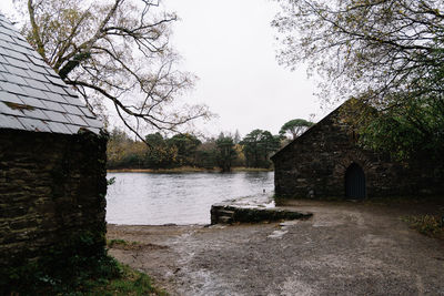 House by lake against clear sky