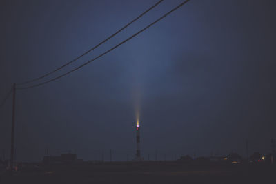 Low angle view of electricity pylon at night