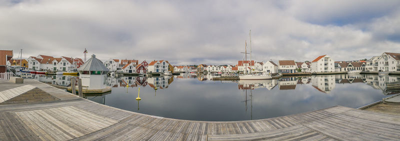 Boats in sea against cloudy sky