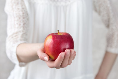 Midsection of woman holding apple