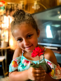 Portrait of smiling girl holding indoors