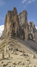 Group of people on rock against sky