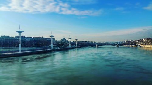 Bridge over river against cloudy sky