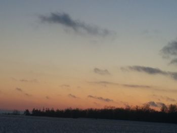 Scenic view of silhouette field against sky at sunset