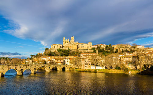 Arch bridge over river against buildings