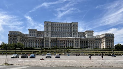 People at palace of the parliament against sky