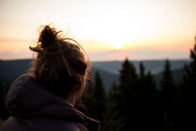 Close-up of woman looking at sky during sunset