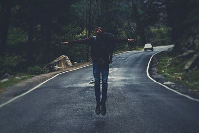 Man on road along trees