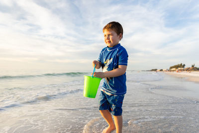 Side view of young man standing at beach