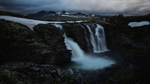 Scenic view of waterfall against sky