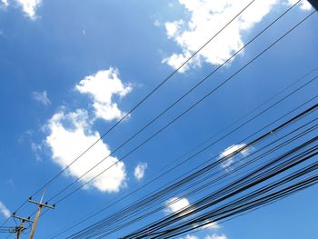 Low angle view of power cables against sky