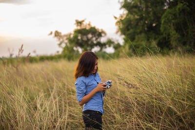 Woman with umbrella standing on field