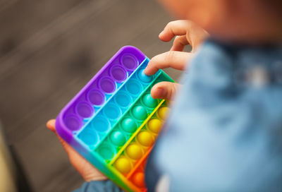 Midsection of man holding multi colored candies