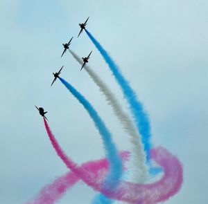 Low angle view of airshow against sky