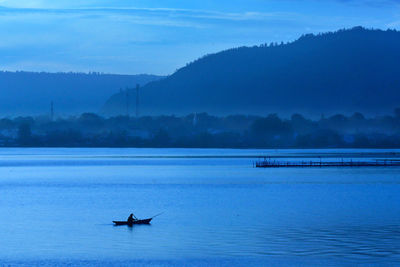 Boat sailing on lake against sky