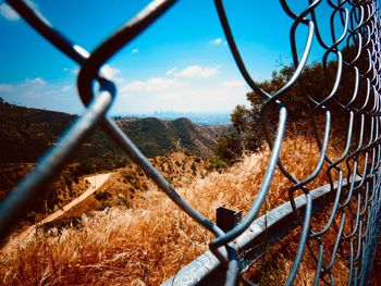 Close-up of chainlink fence against sky