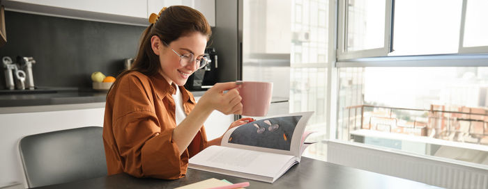 Young woman using laptop while sitting at home