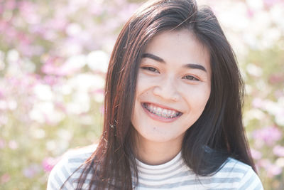 Close-up portrait of young woman smiling at park