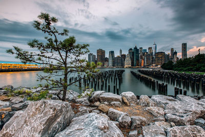 Scenic view of river by buildings against sky