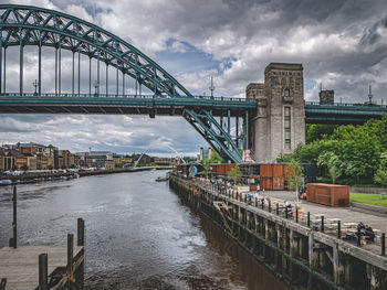 Bridge over river against cloudy sky