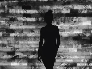 Woman standing against brick wall