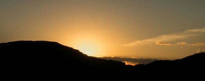 Scenic view of silhouette mountains against sky during sunset