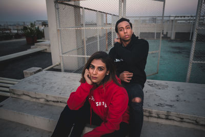 Portrait of young couple sitting outdoors